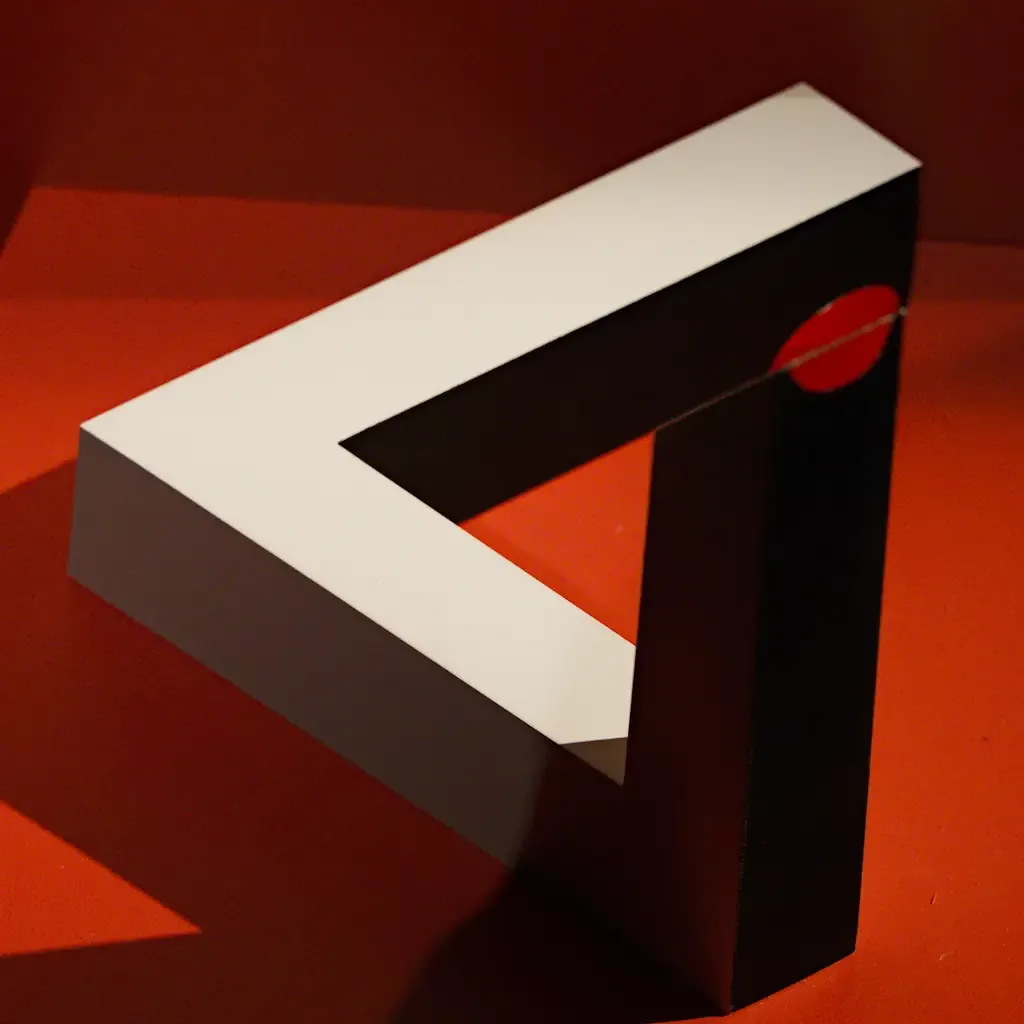 AI generated alt: sculpture of a Penrose triangle in white and black on a deep red ground, lit so the join reads as continuous.